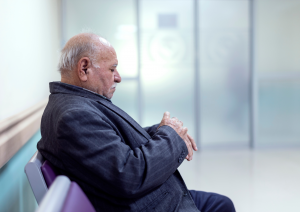 <img src="image.s”vg alt=“elder man sitting in the coridoor of a hospital and checking his watch">